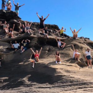 Students on a small mountain posing for the photo.